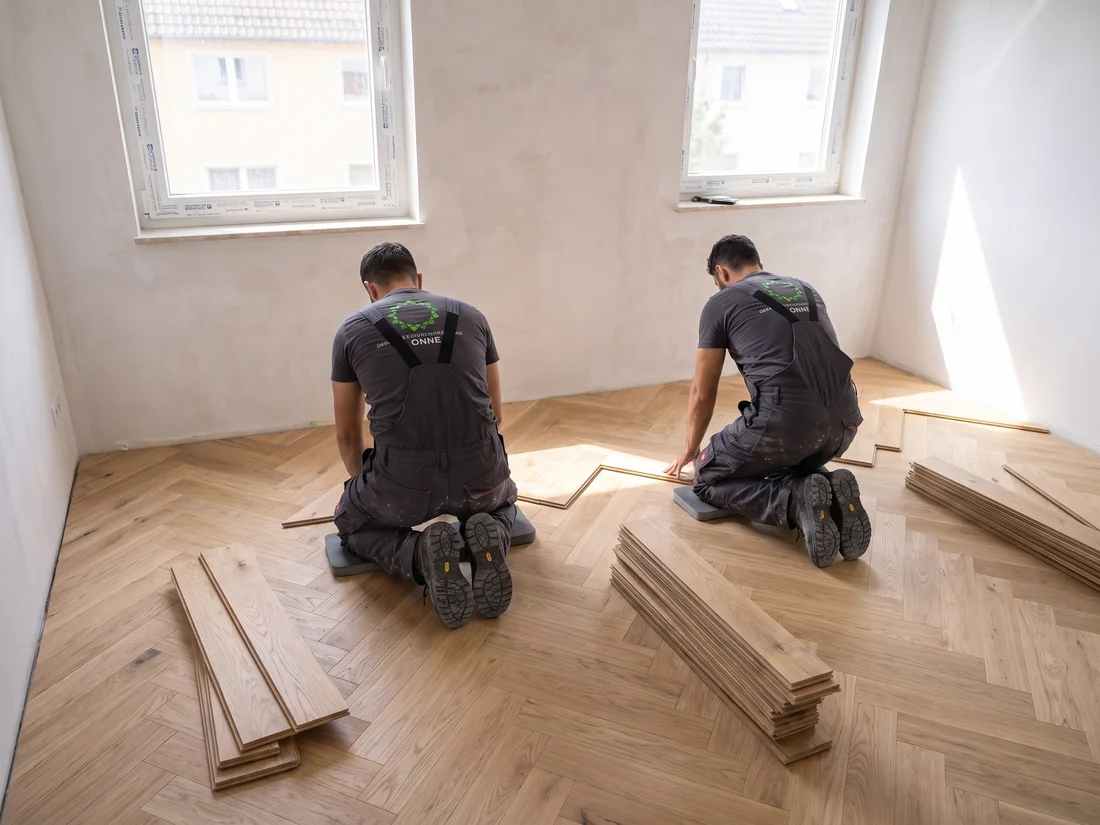 Verlegen von Fischgrätparkett in einer Wohnung (Symbolbild, KI-generiert)